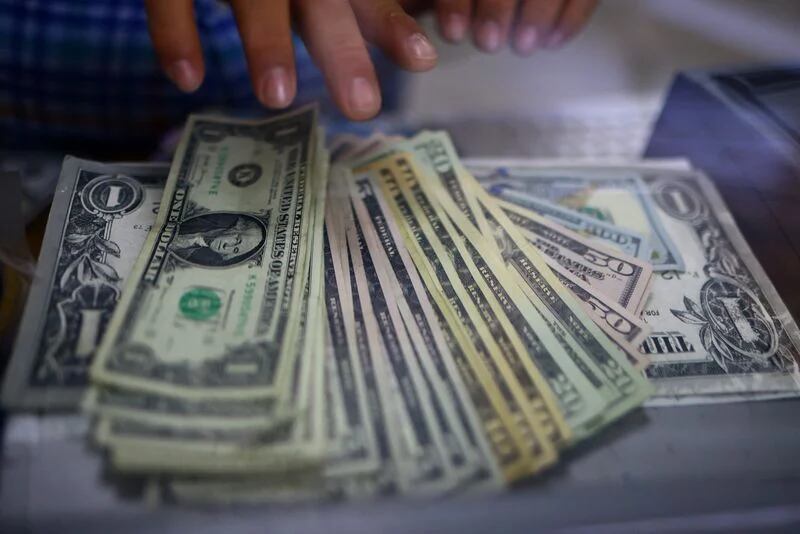 FOTO DE ARCHIVO-El empleado de una tienda de cambio de divisas cuenta billetes de dólares estadounidenses en Ciudad Juárez, México. 27 de julio de 2023. REUTERS/José Luis González