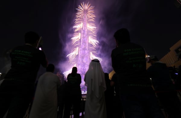 La gente ve estallar fuegos artificiales alrededor del Burj Khalifa, el edificio más alto del mundo, durante las celebraciones de Año Nuevo en Dubai, Emiratos Árabes Unidos (REUTERS/Christopher Pike)