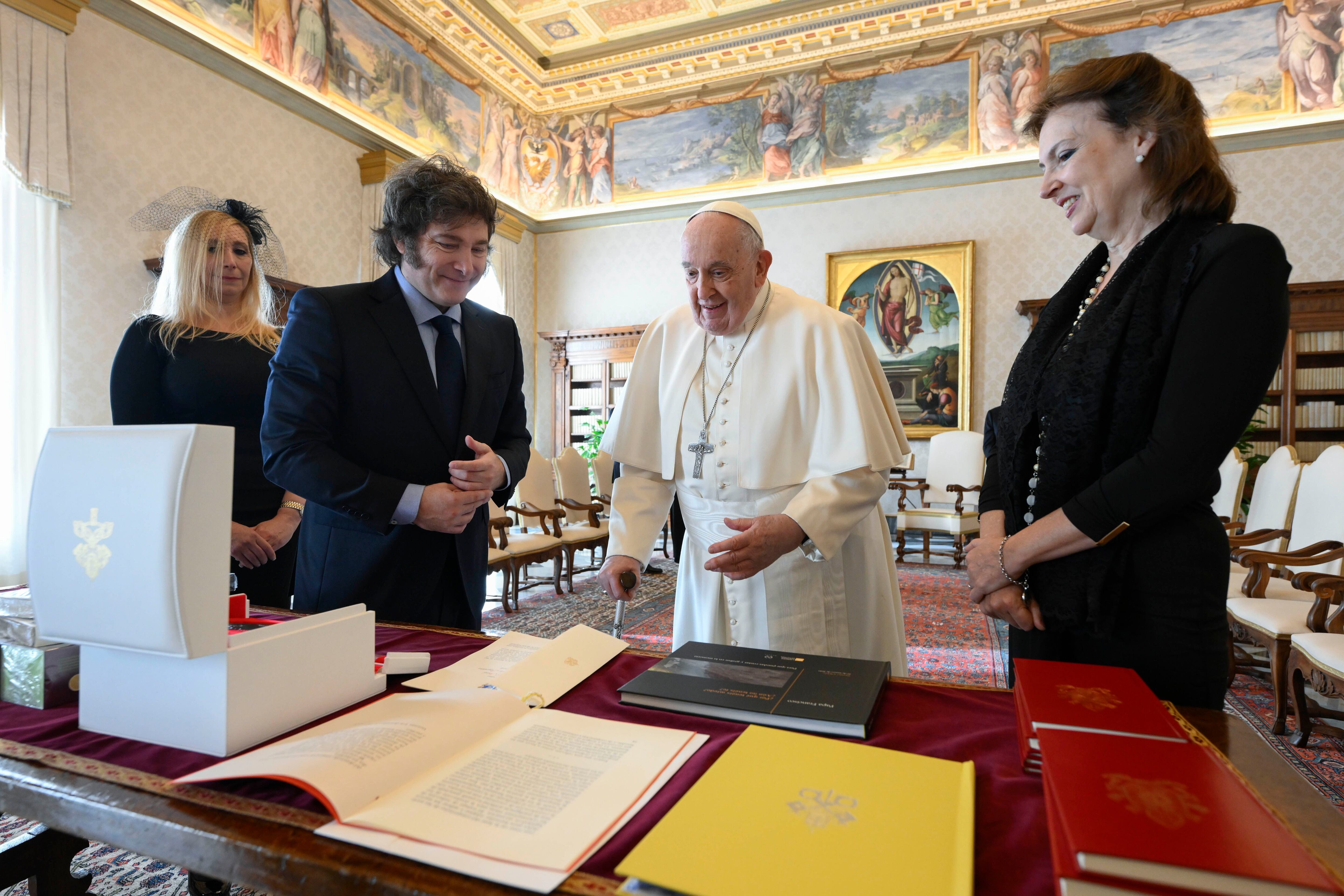 En la foto, el presidente Milei, la secretaria general de la Presidencia, Karina Milei,  y la canciller Diana Mondino intercambian regalos con el papa Francisco en el estudio del pontífice (Vatican Media vía AP, HO)