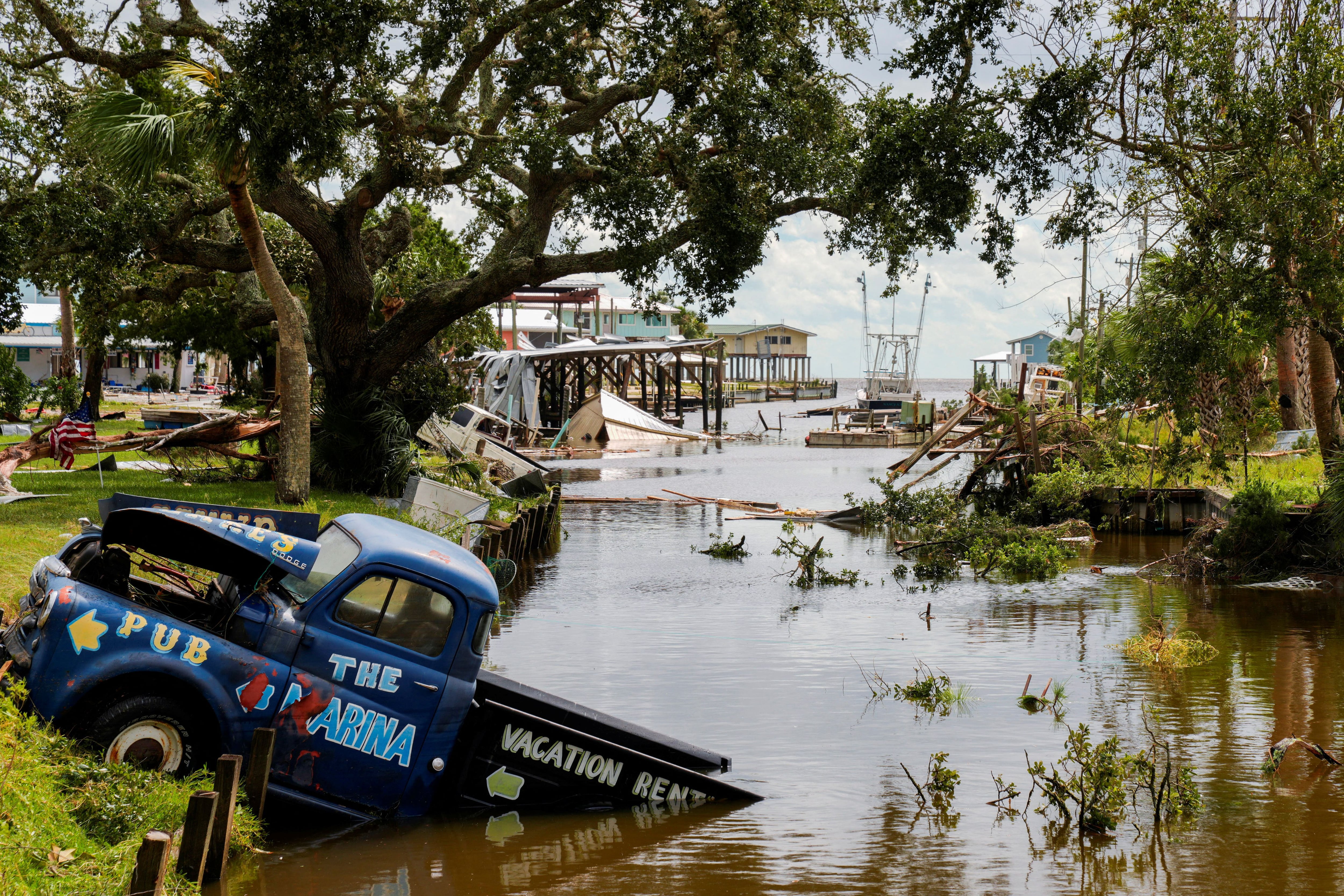 A partially submerged vehicle is seen in a canal after Hurricane Italia made landfall in Horseshoe Beach, Florida, U.S., on August 30, 2023.  REUTERS/Cheney Orr