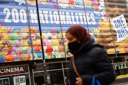 Una mujer con máscara camina por Londres, durante el brote de coronavirus. REUTERS/John Sibley