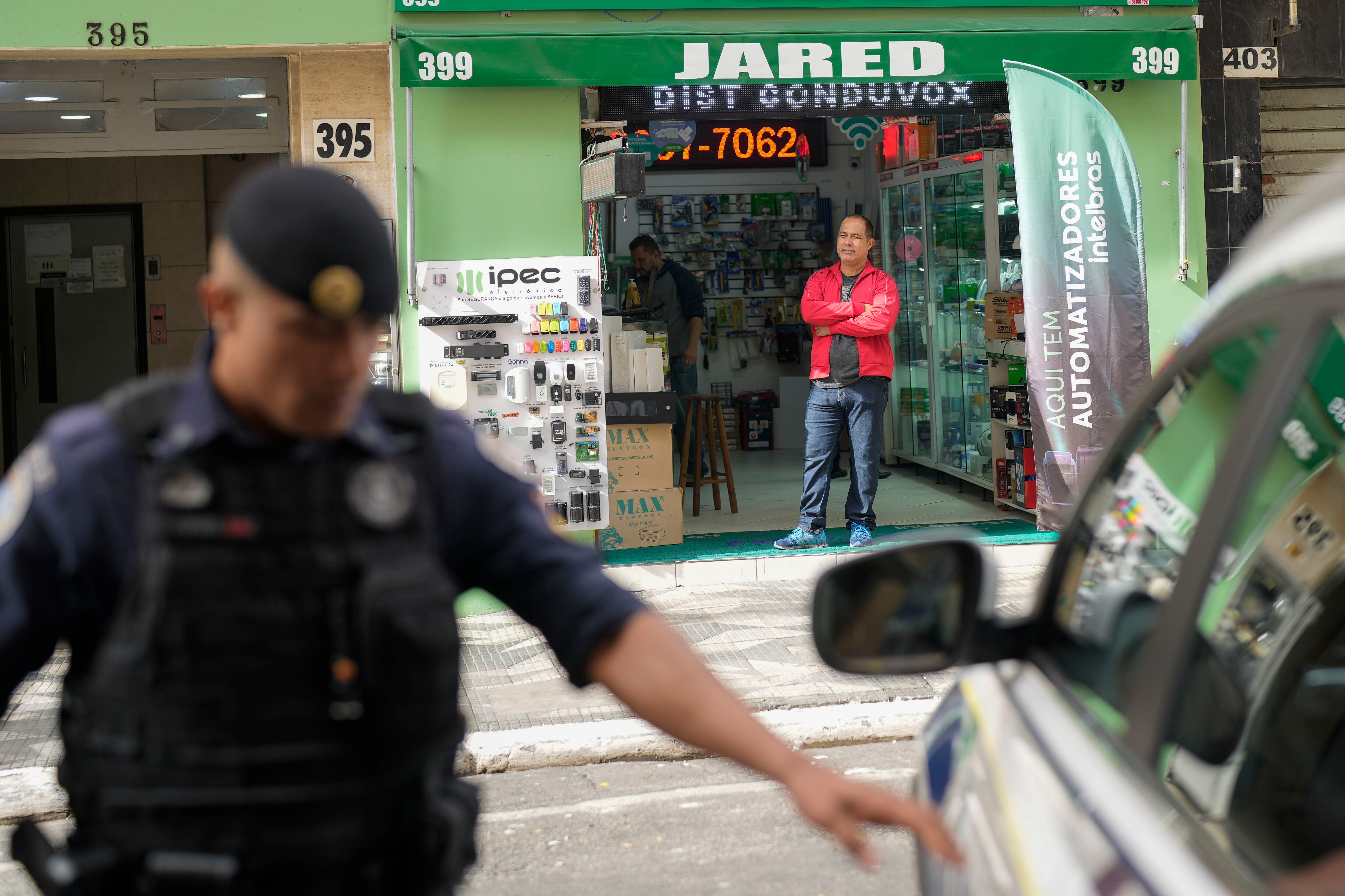 Un comerciante se ve pie en la entrada de su tienda en la zona comercial de Santa Efigenia, un núcleo de tiendas de electrónica, después de una reciente operación policial contra consumidores de drogas sin hogar en el centro de Sao Paulo. (AP Foto/Andre Penner)