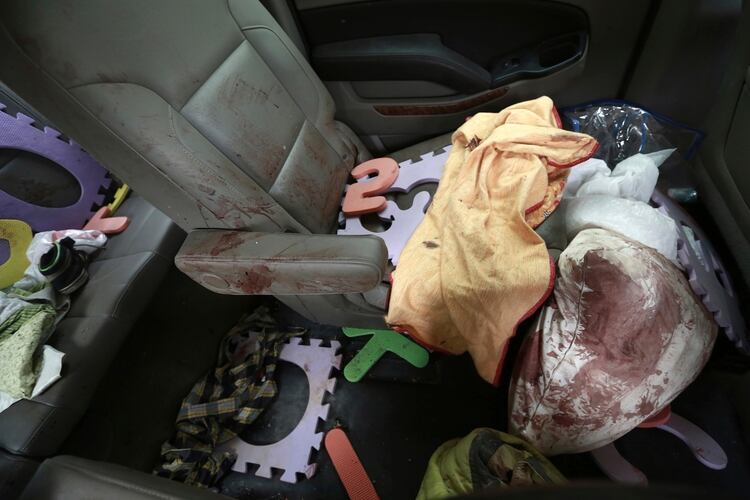 Prendas y juguetes ensangrentados vistos en el interior de una camioneta baleada en la que viajaban miembros de la familia LeBarón, estacionada en una carretera de tierra en Bavispe, cerca de la frontera entre los estados mexicanos de Sonora y Chihuahua, el 6 de noviembre de 2019. (Foto: AP/Christian Chávez)