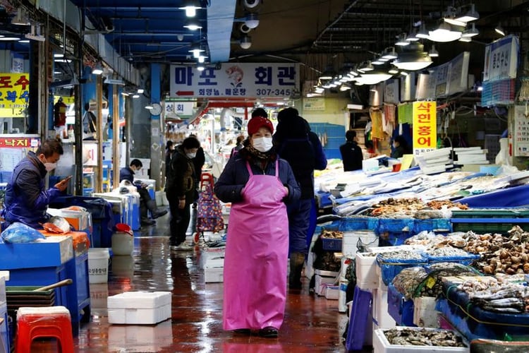 Un comerciante con una mascarilla para evitar contraer el coronavirus en un mercado tradicional de Seúl (Corea del Sur) 