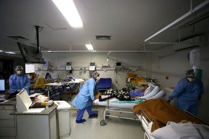 Trabajadores de la salud trasladan a un paciente de la sala de emergencias del hospital Nossa Senhora da Conceição en medio de la pandemia de coronavirus, en Porto Alegre, Brasil, Marzo 11, 2021 (REUTERS/Diego Vara)