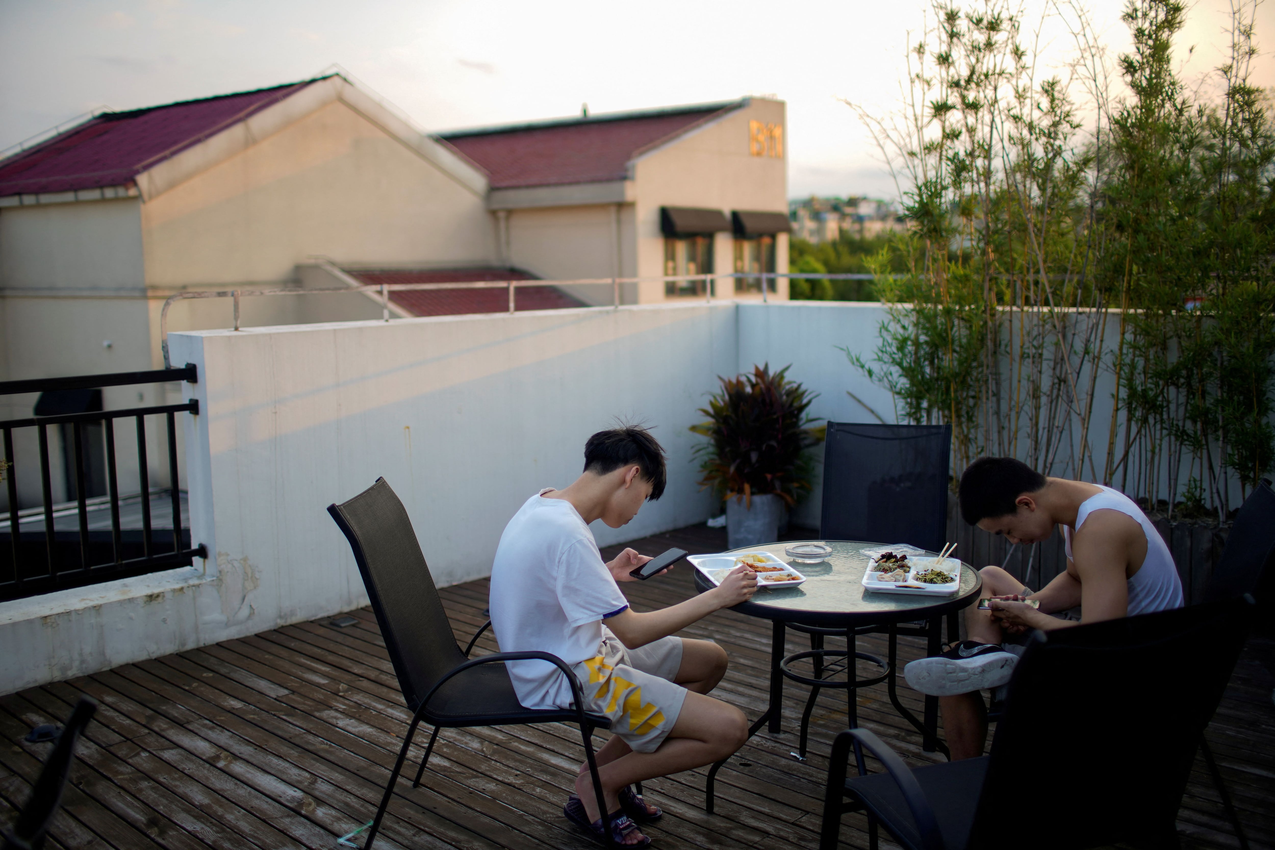 Jóvenes con sus celulares en una cafetería de Shanghái (Reuters)