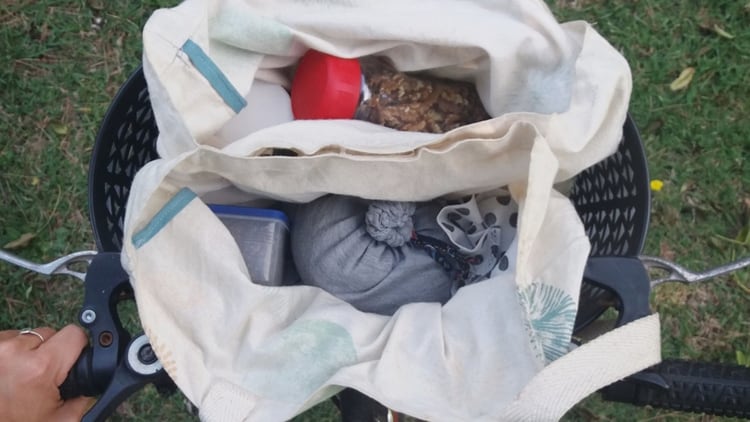 Así lucen las compras de Edelmira, bolsas de tela y frascos de vidrio en el canasto de su bicicleta