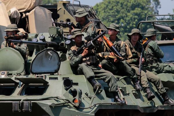 Un grupo de soldados venezolanos sentados sobre un vehículo BTR-80A. Están armados con lanzagranadas, lanzamisiles RPG-7V, Carl Gustav M2 y fusiles Ak-103 (AFP)