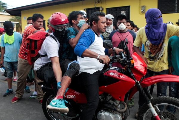Manifestantes socorren a un herido. (REUTERS/Oswaldo Rivas)