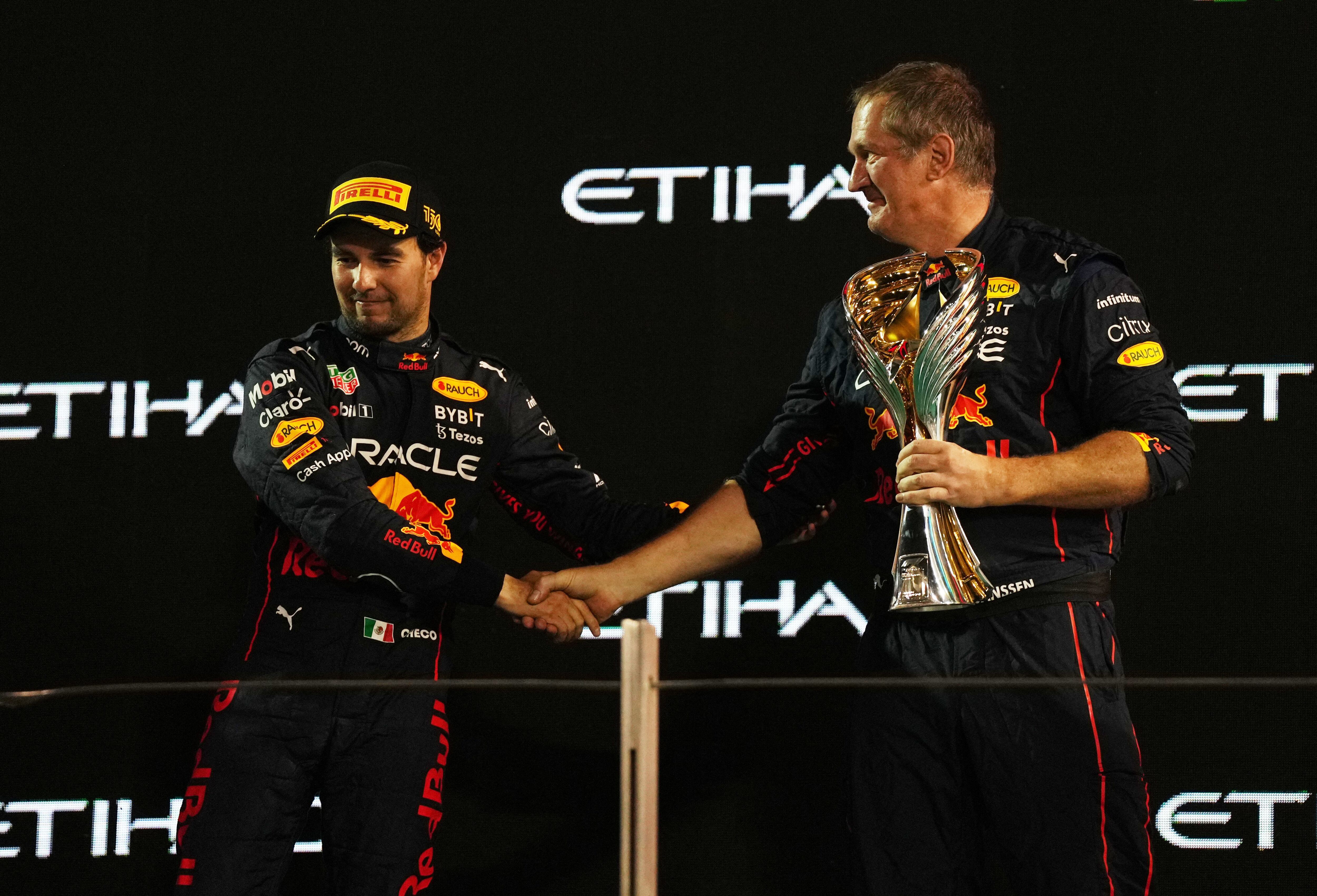 Formula One F1 - Abu Dhabi Grand Prix - Yas Marina Circuit, Abu Dhabi, United Arab Emirates - November 20, 2022 Red Bull's trackside Infrastructure Group Leader Olaf Janssen hold the constructors winner trophy on the podium as he shakes hands with third placed Red Bull's Sergio Perez REUTERS/Aleksandra Szmigiel