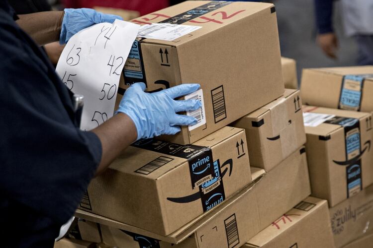 An employee arranges Amazon.com Inc. packages before delivery at the United States Postal Service Joseph Curseen Jr. and Thomas Morris Jr. processing and distribution center in Washington. MUST CREDIT: Bloomberg photo by Andrew Harrer