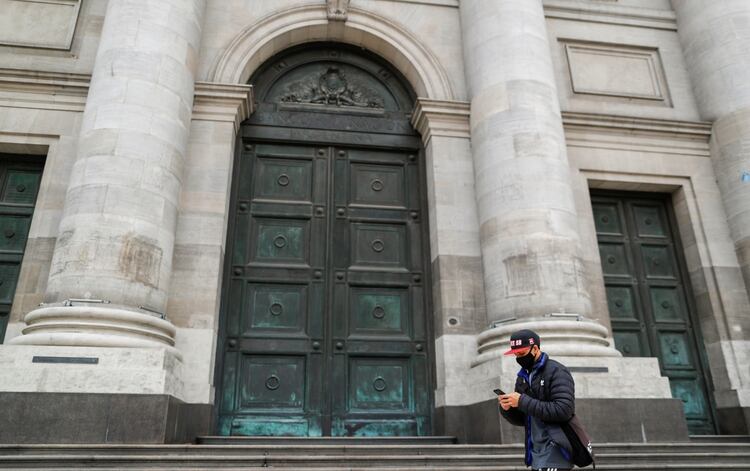 Un hombre con tapabocas camina frente a la sede central del Banco Nación en Buenos Aires. Reuters