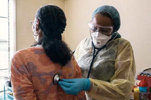 FILE -- Rochelle Allen, right, a respiratory therapist, listens to the lungs of a patient with asthma during a home visit in Oakland, Calif., March 4, 2020. Despite warnings that asthmatics were at higher risk for severe illness from the coronavirus, asthma is showing up in only about five percent of New York State’s fatal Covid cases. (Alexandra Hootnick/The New York Times)