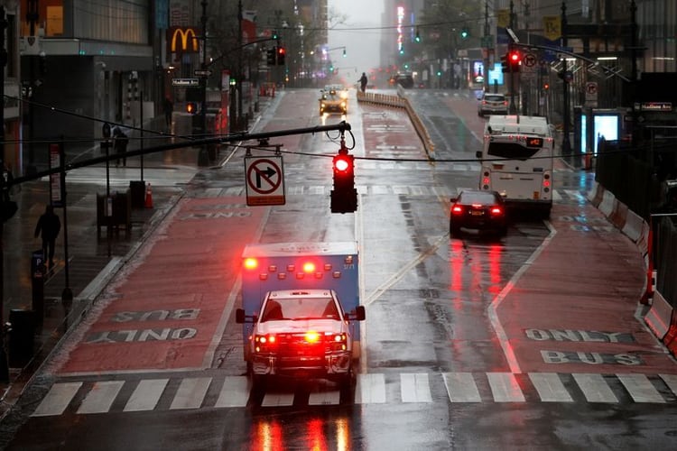 Una ambulancia cruza la calle 42 Este, casi vacía, bajo fuertes lluvias y vientos en Manhattan durante el brote de la enfermedad coronavirus (COVID-19) en la ciudad de Nueva York, Nueva York, EEUU, el 13 de abril, 2020. REUTERS/Mike Segar