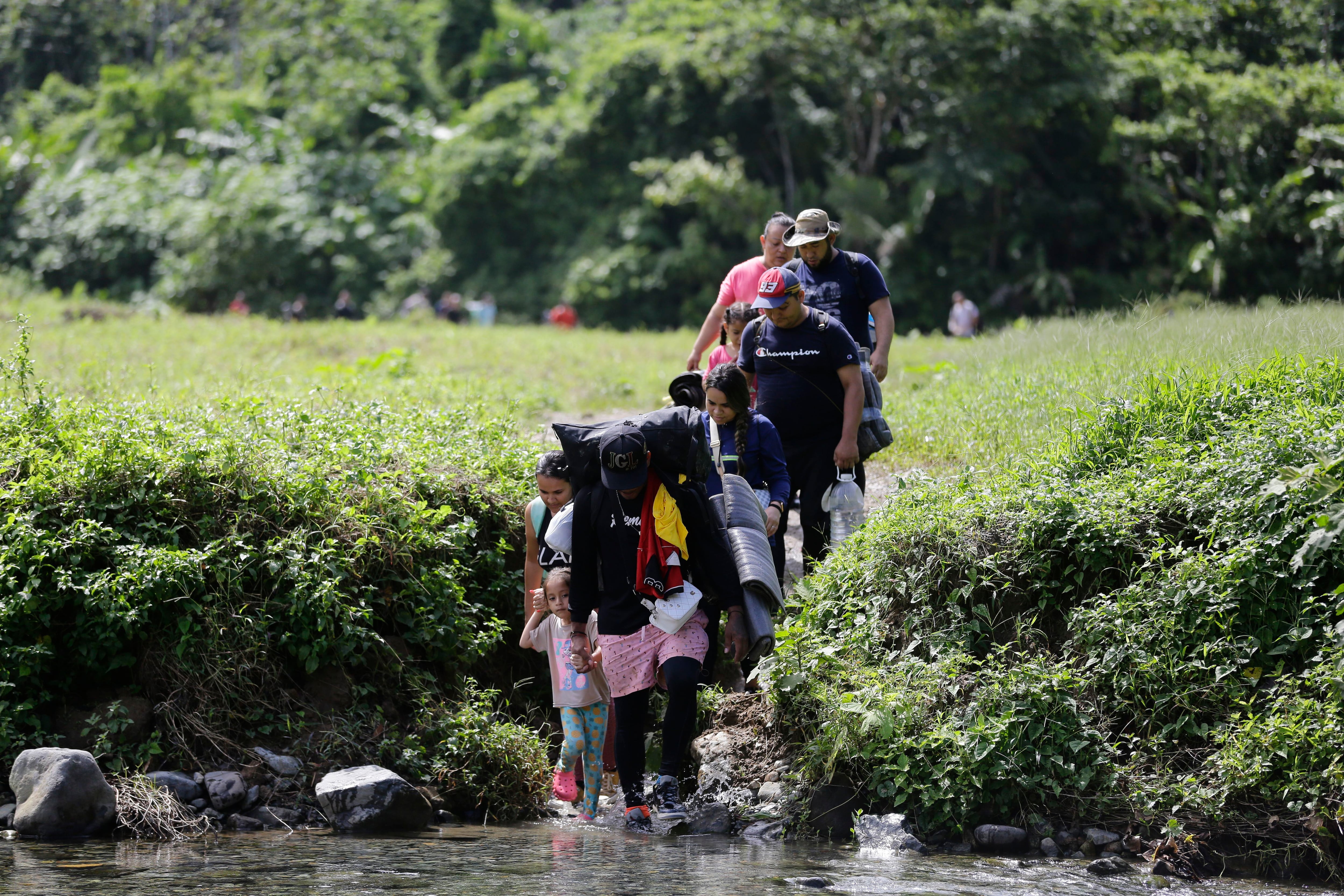 Fotografía de archivo fechada el 18 de agosto de 2023 donde aparecen unos migrantes acompañados con niños pequeños mientras caminan en el sector de Cañas Blancas en Darién (Panamá). EFE/Carlos Lemos
