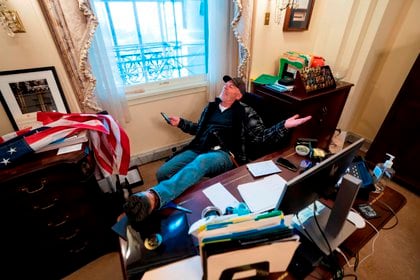Un seguidor de Donald Trump, identificado como Richard Barnett, se sienta en el escritorio de la presidenta de la Cámara Baja, Nancy Pelosi, luego de irrumpir en el Capitolio estadounidense durante protestas el 6 de enero, en Washington (Estados Unidos). EFE/ JIM LO SCALZO

