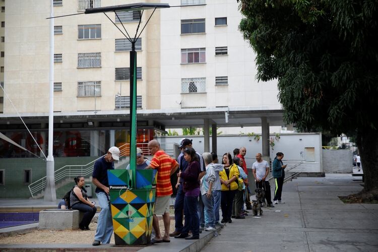 Ciudadanos hacen fila para cargar los celulares en un puesto de energÃ­a solar (REUTERS/Carlos Garcia Rawlins)