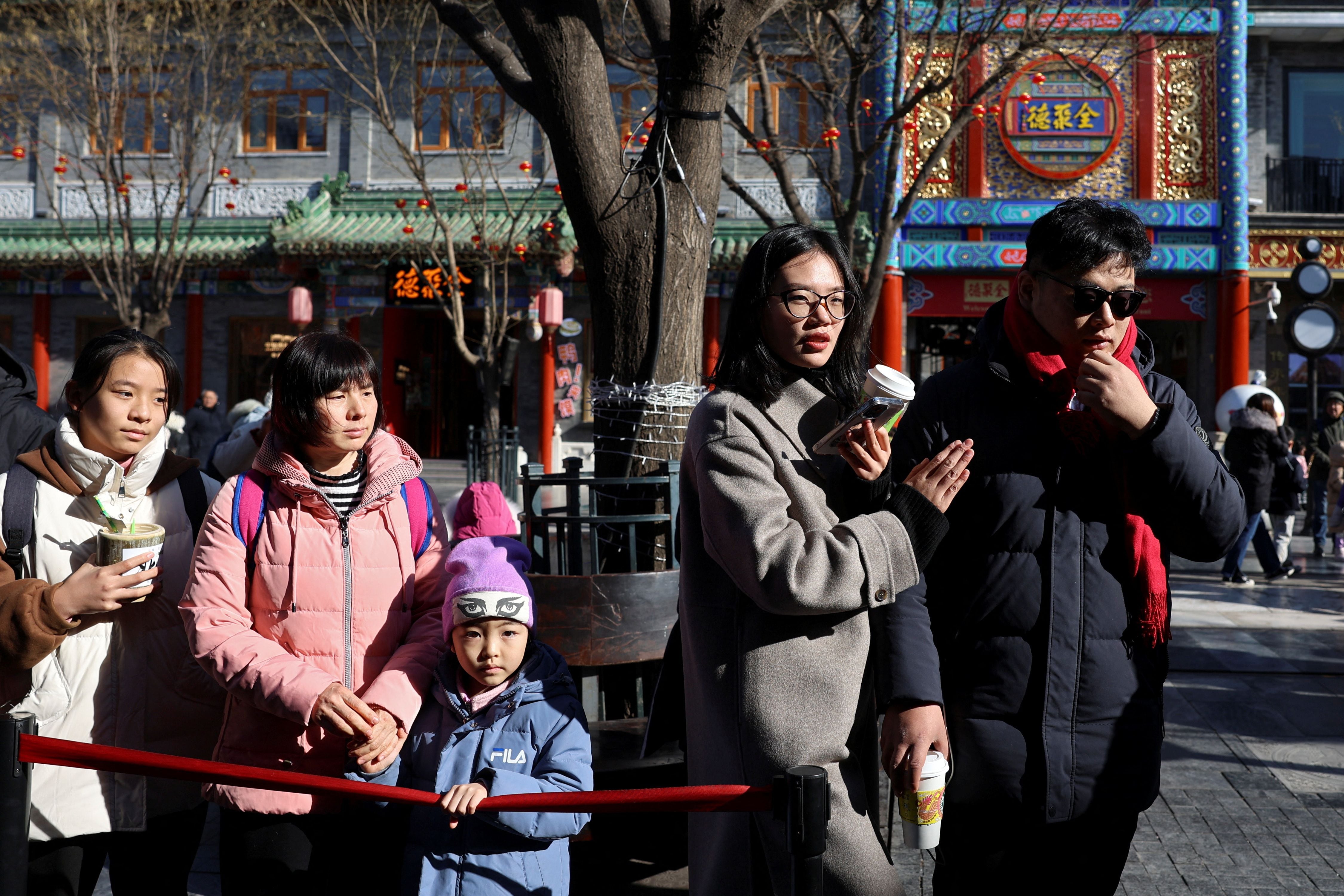 La gente hace cola frente a un restaurante en la calle peatonal Qianmen de Beijing, China, 26 de enero de 2024. REUTERS/Florence Lo