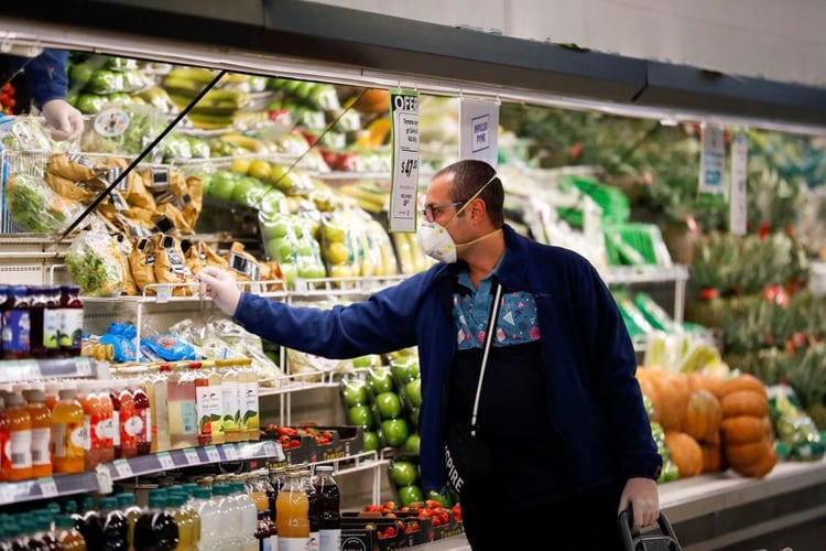 Un hombre con barbijo compra en un supermercado mientras los habitantes comienzan a acopiar alimentos tras el brote de coronavirus, en Buenos Aires, Argentina, el 15 de marzo de 2020. REUTERS/Agustin Marcarian