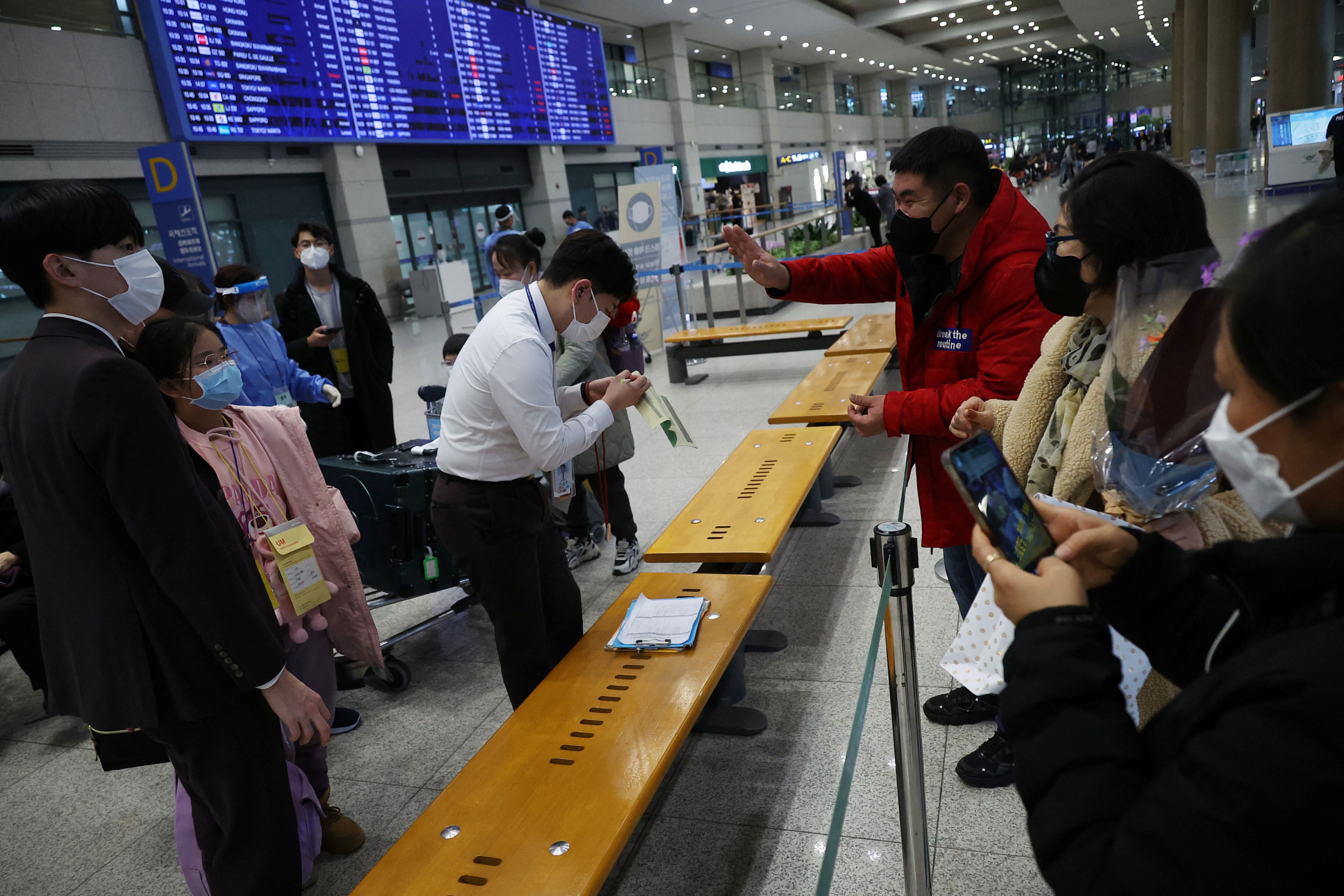 Una familia china se reúne con su hija, mientras un grupo de chinos son separados para ir al centro de pruebas de la enfermedad por coronavirus (COVID-19), a su llegada al Aeropuerto Internacional de Incheon en Incheon, Corea del Sur, 12 de enero de 2023. REUTERS/Kim Hong-Ji/Archivo