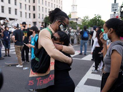 Dos personas se abrazan durante las protestas por la muerte de George Floyd en EEUU. REUTERS/Ken Cedeno