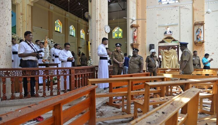 Policías y sacerdotes revisan la escena de una de las explosiones (Reuters)