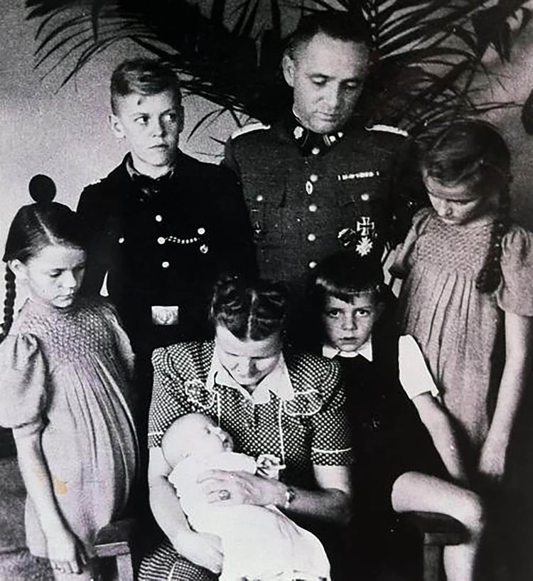 Rudolf Höss vivió con su familia -esposa y cinco hijos- en la casa que le correspondía como comandante en las afueras del campo de exterminio de Auschwitz. Brigitte, la mayor de las niñas, creció viendo a los prisioneros con sus trajes a rayas y las chimeneas humeantes de los hornos nazis