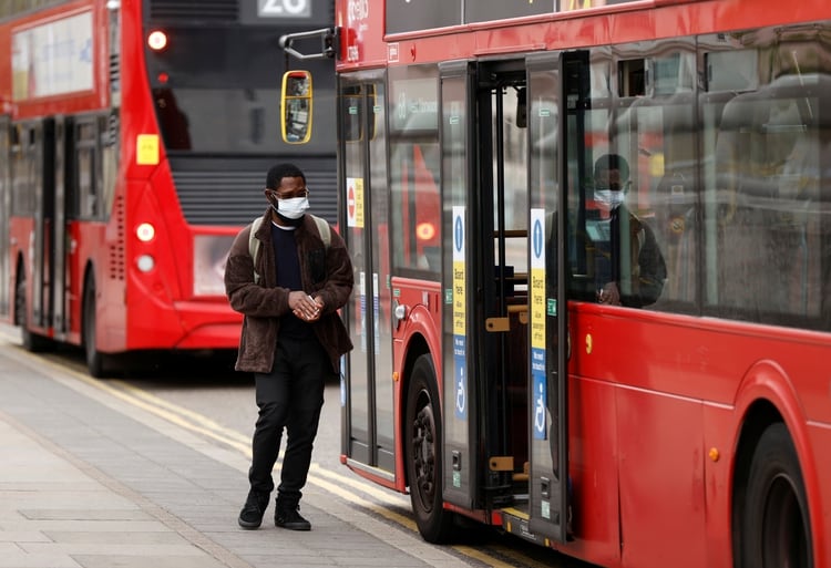 Un hombre con máscara facil se sube al autobús en Londres REUTERS/John Sibley