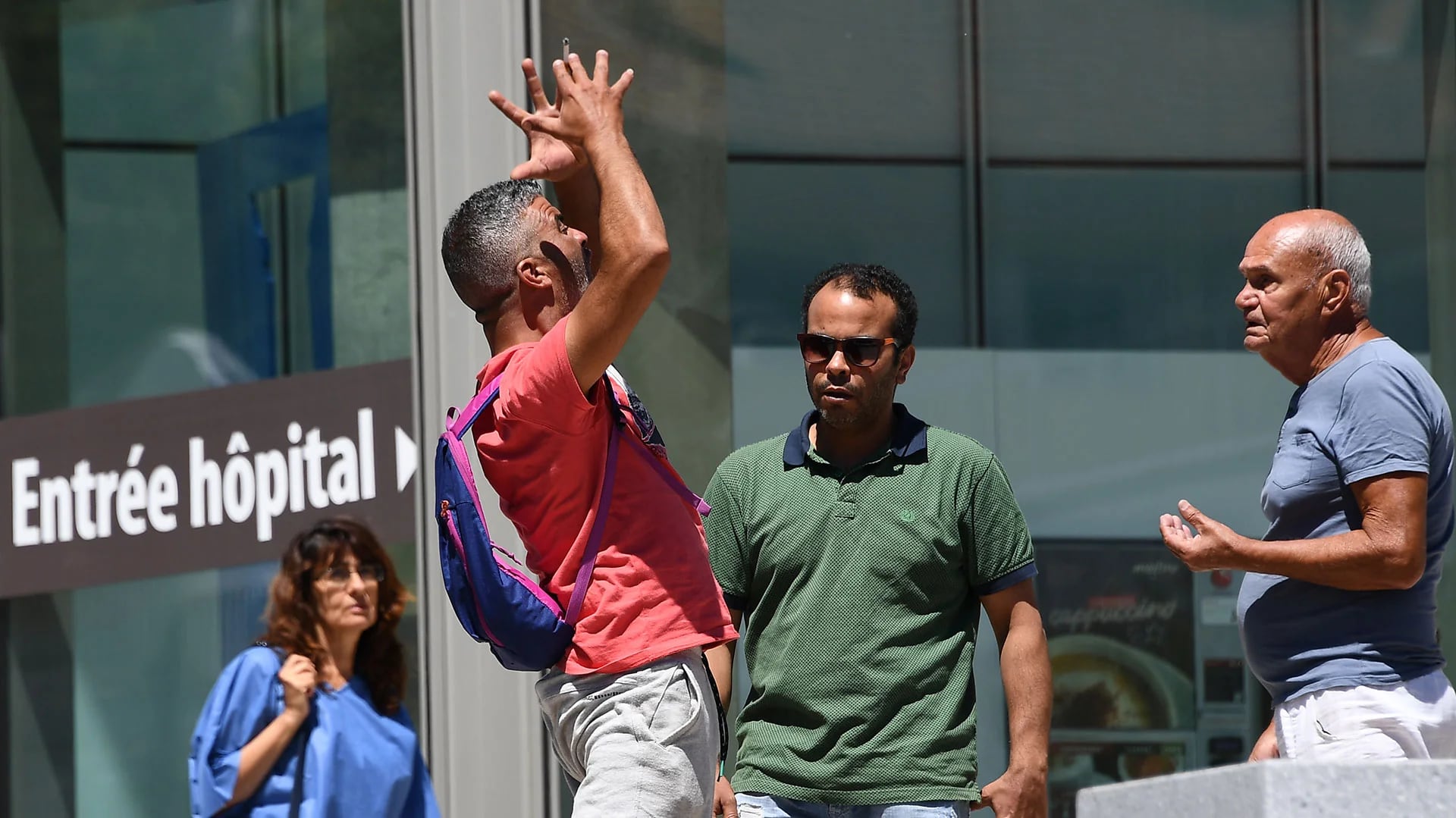 Un hombre exaltado junto a otros dos esperan noticias sobre los heridos en un hospital de Niza (AFP)