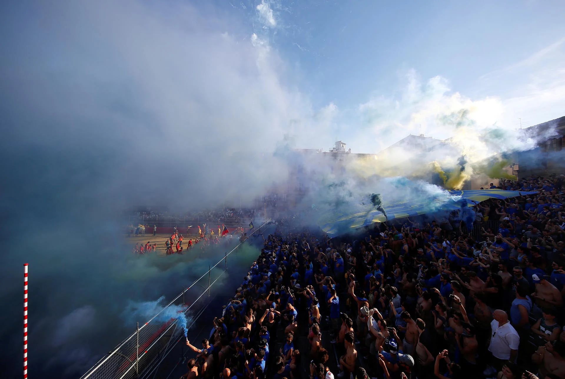 Fanáticos del equipo italiano Santa Croce celebran con bengalas y una gran bandera luego de un partido de Calcio Fiorentino, un estilo primitivo del fútbol convencional (Reuters)