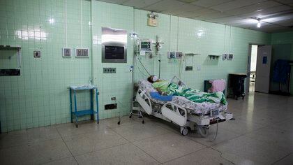 A patient recovering from colon cancer surgery lies alone in the ICU of the Luis Razetti Oncology Hospital in Caracas, Venezuela, Wednesday, Sept. 2, 2020. The hospital, which stopped admitting new cancer patients at the start of the mid-March lockdown to curb the spread of COVID-19, lacks water, air conditioning, supplies like lab materials, and even doctors, while only one of the five operating rooms is operational. (AP Photo/Ariana Cubillos)