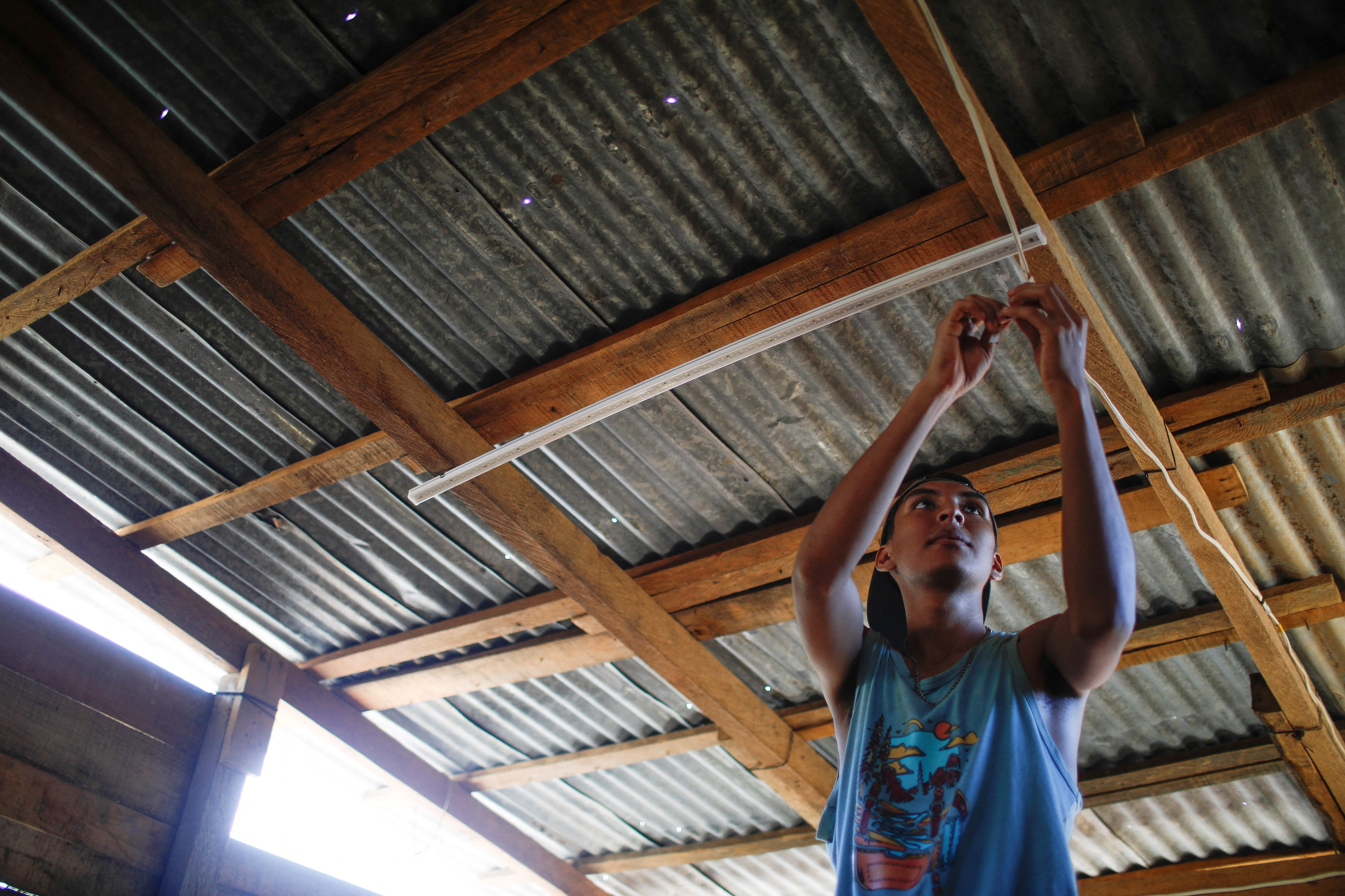 Kevin Cartagena, 19, repairs electricity cables of his mother's house, at Colonia Puesta del Sol a month after Hurricane Otis hit Acapulco, Mexico November 26, 2023. REUTERS/Raquel Cunha