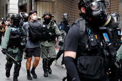 Agentes de la policía antidisturbios detienen a un manifestante antigubernamental durante unas protestas que tuvieron lugar en el Distrito Central en Hong Kong, China, el 27 e mayo de 2020. REUTERS/Tyrone Siu