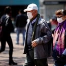 People walk on the street, wearing protective masks as a preventive measure against the spread of the coronavirus disease (COVID-19), in Bogota, Colombia March 17, 2020. REUTERS/Leonardo Munoz. NO RESALES. NO ARCHIVES.
