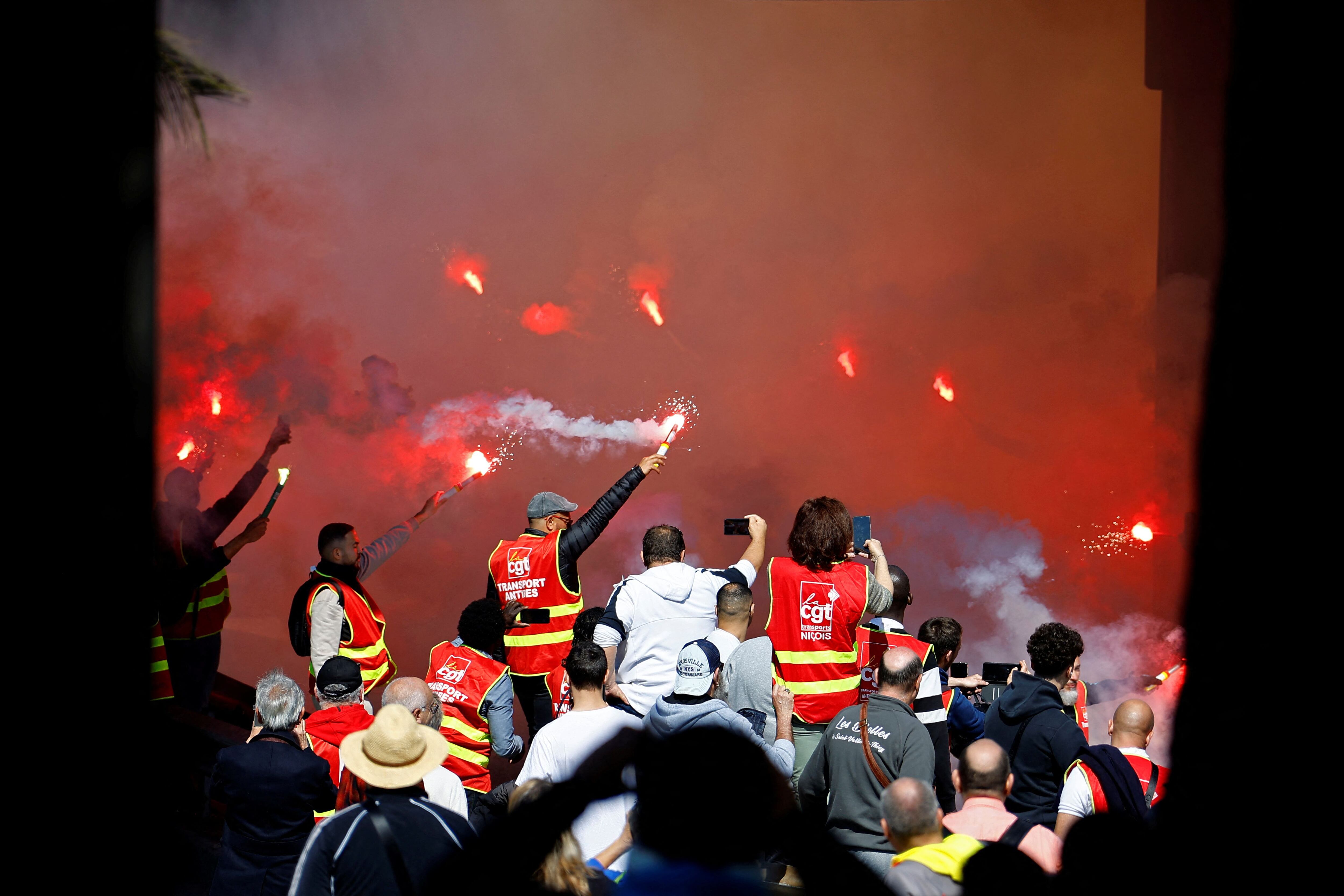 Manifestantes, con chalecos del sindicato CGT, sostienen bengalas rojas durante una manifestación en Niza este jueves (REUTERS/Eric Gaillard)