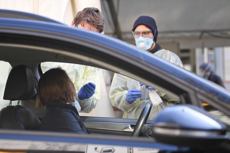Empleados médicos de laboratorio extraen una muestra a una persona en Munich (REUTERS/Andreas Gebert)