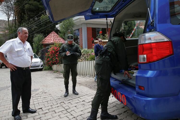 Policías inspeccionan el baúl de un vehículo en la entrada de Urbanización La Rinconada, donde se encuentra la residencia del embajador de México, en La Paz, Bolivia. 30 de diciembre de 2019. REUTERS/David Mercado