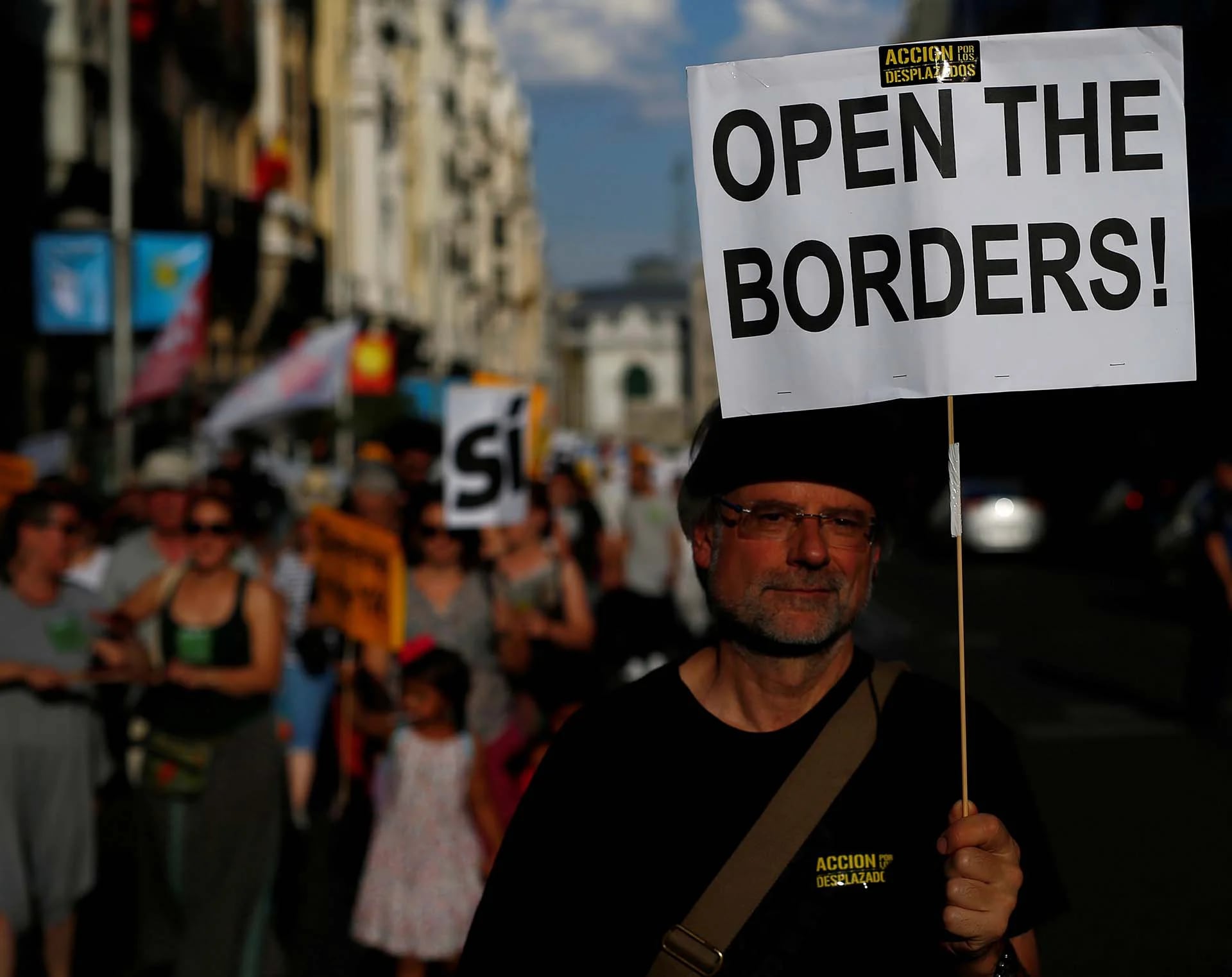 Un hombre marcha en Madrid pidiendo la apertura de las fronteras durante un acto por el Día Mundial del Refugiado