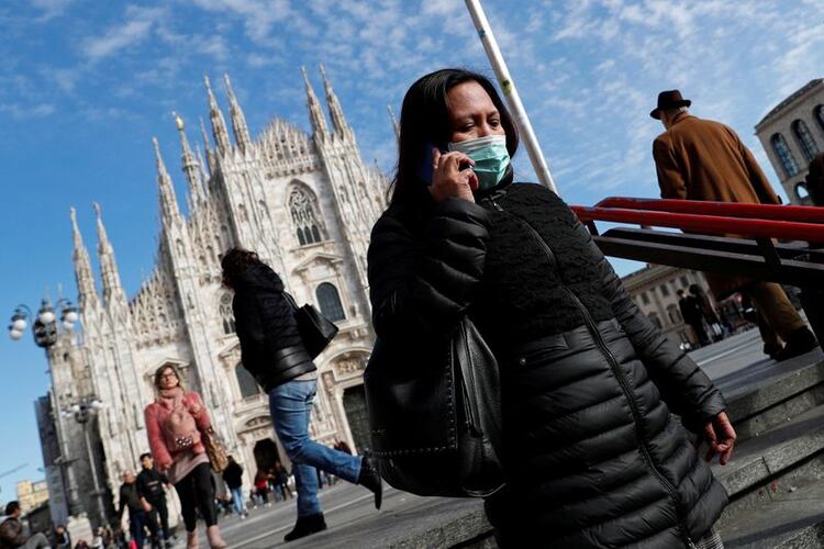 Una mujer con una mascarilla para evitar contraer el coronavirus ingresa a una estación de metro en Milán, Italia (REUTERS/Guglielmo Mangiapane.)