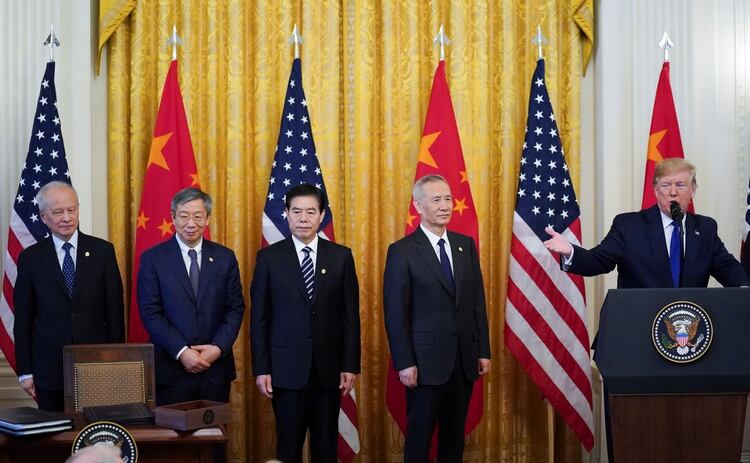Viceprimer ministro chino Liu He y su equipo escuchan al presidente de Estados Unidos Donald Trump mientras habla al comienzo de la ceremonia de firma de la 