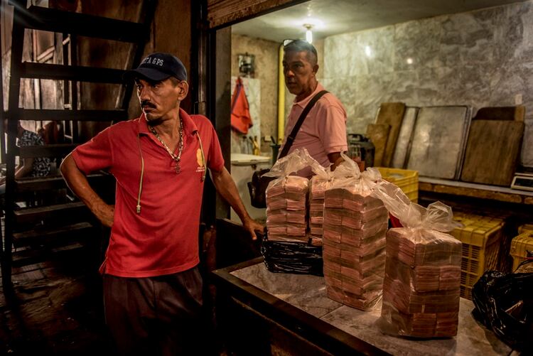  Bolsas de dinero, que han perdido buena parte de su valor, en un puesto mercado popular de alimentos en Maracaibo. (Meridith Kohut/The New York Times)