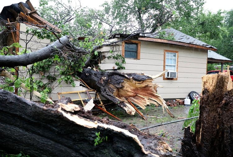 Un gran árbol descansa dentro de una casa donde un hombre fue rescatado cerca de Newton y St. Louis Avenue en Tulsa, Oklahoma, el martes 21 de mayo de 2019 (AP)