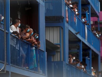 Trabajadores de Bangladesh, India y China miran por sus balcones durante la distribución de alimentos en el dormitorio de Punggol S-11, que se convirtió en una instalación de aislamiento después de que se registró allí un foco de covid-19 (REUTERS / Edgar Su)