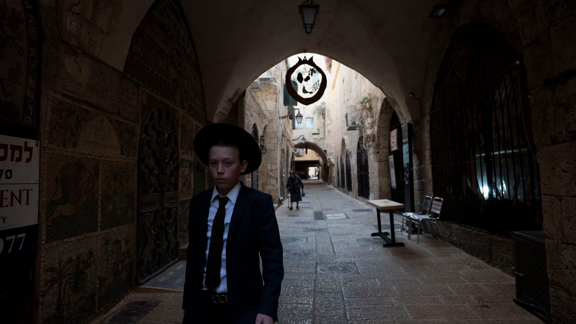 Un niño judío camina sólo rumbo al Muro de los Lamentos, en una calle de Jerusalén que habitualmente está desbordante de turistas y vendedores