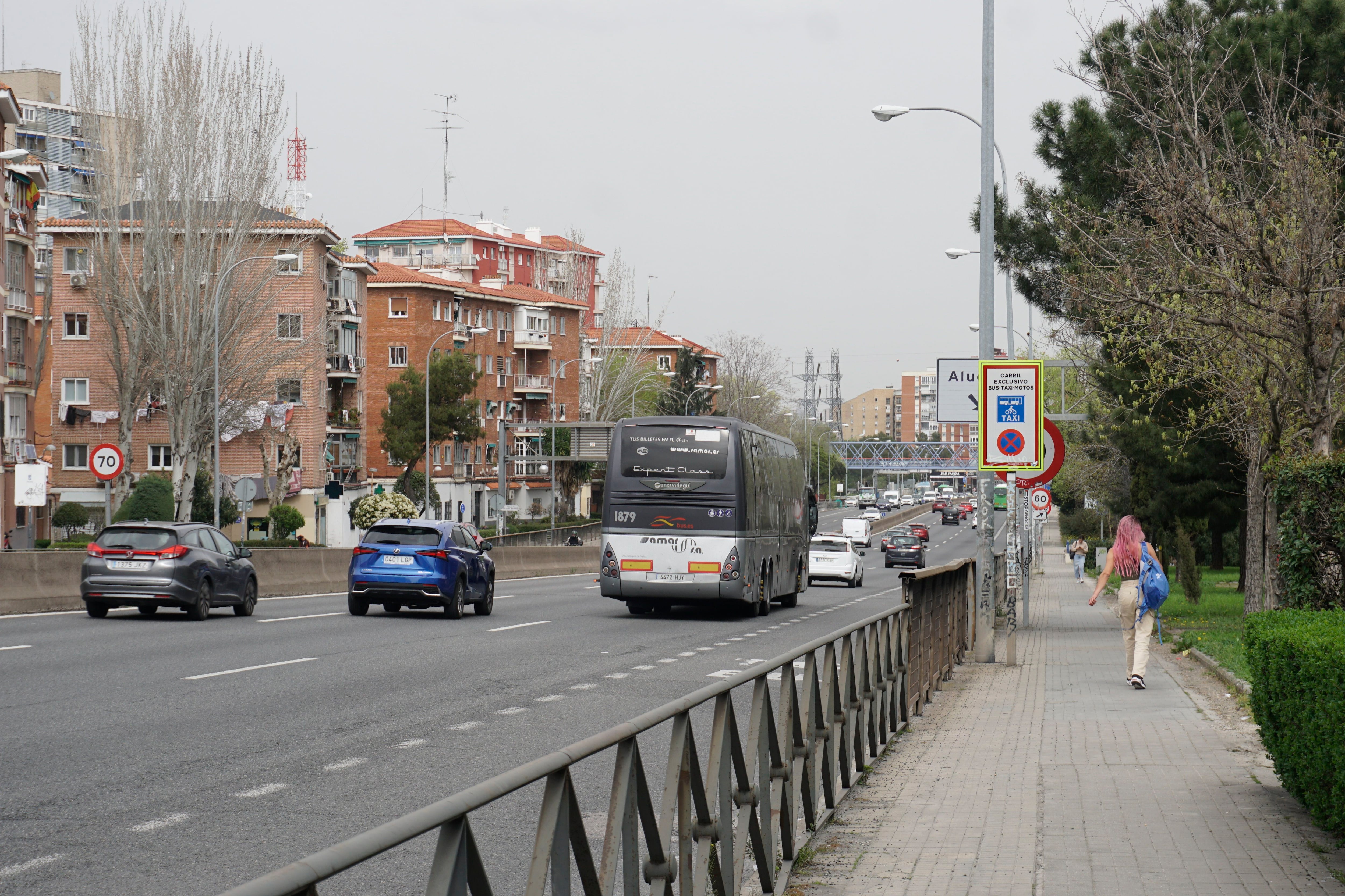Una joven camina por el Paseo de Extremadura mientras los coches circulan por la A-5 (Infobae España)
