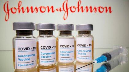FOTO DE ARCHIVO: Viales con una pegatina en la que se lee: "COVID-19 / Vacuna contra el coronavirus / Sólo inyección" y una jeringuilla se ven delante de un logotipo de Johnson & Johnson mostrado en esta ilustración tomada el 31 de octubre de 2020. REUTERS/Dado Ruvic/Illustration