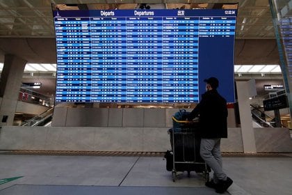 En esta imagen de archivo, un pasajero mira un panel de salidas en el aeropuerto Charles de Gaulle de París, que muestra vuelos cancelados con destino a Londres y Bristol, el 21 de diciembre de 2020. REUTERS/Gonzalo Fuentes