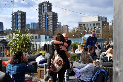 Personas se abrazan en un bar en Londres (Reuters)