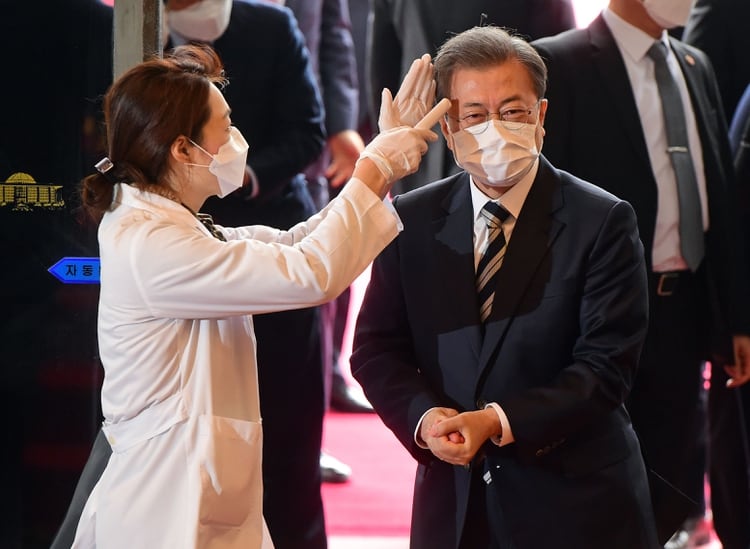 El presidente Moon Jae-in se somete a una prueba de temperatura a su llegada a la Asamblea Nacional en Seúl, Corea del Sur, el 28 de febrero de 2020 (Yonhap, a través de los editores de Reuters)