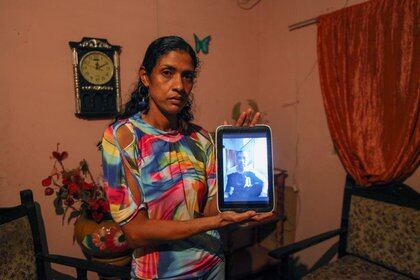 Lesnee Martinez, esposa de Giovanni Urbaneja, posa con una foto de su esposo en su casa en San Jose de Guanipa (Reuters)
